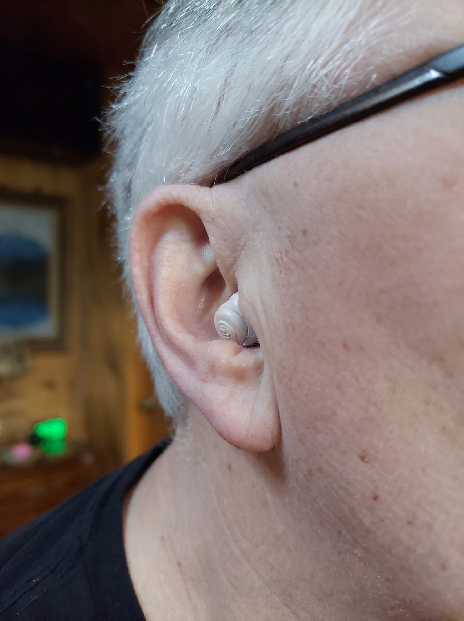 Close-up of a hearo hearing aid worn by a customer — nearly invisible in the ear canal