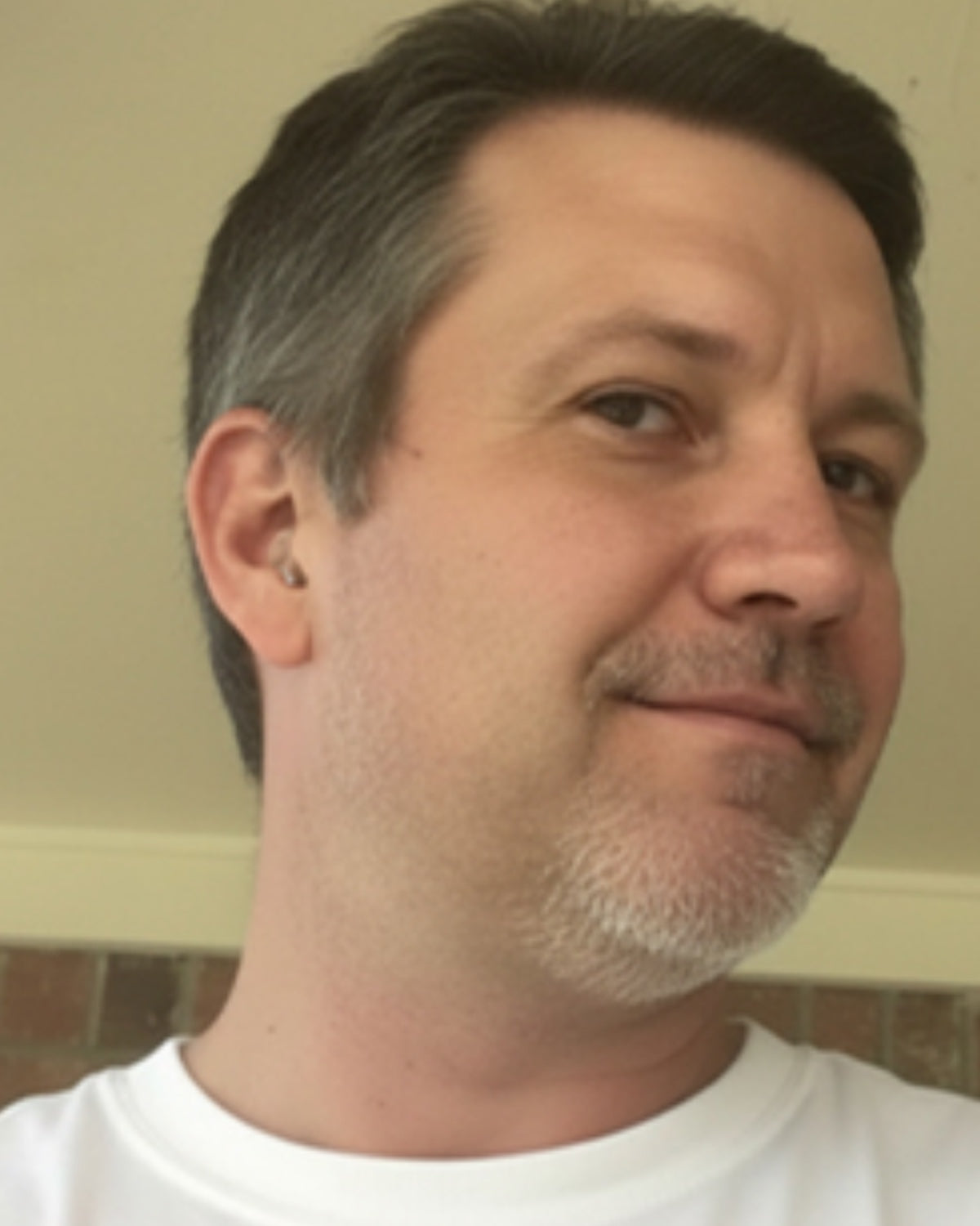 A hearo customer at home — the aid sits invisibly in his ear
